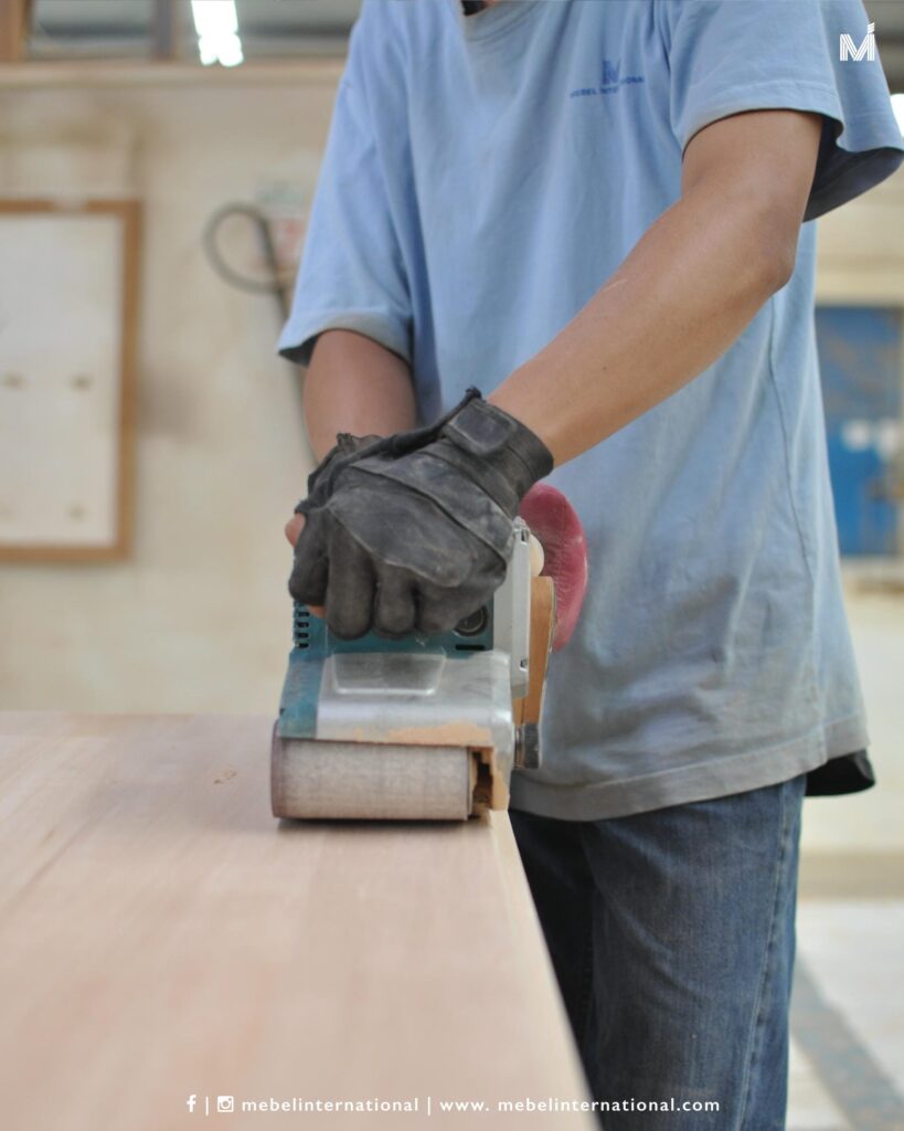 Mebel International furniture manufacturer worker sanding wooden furniture panel