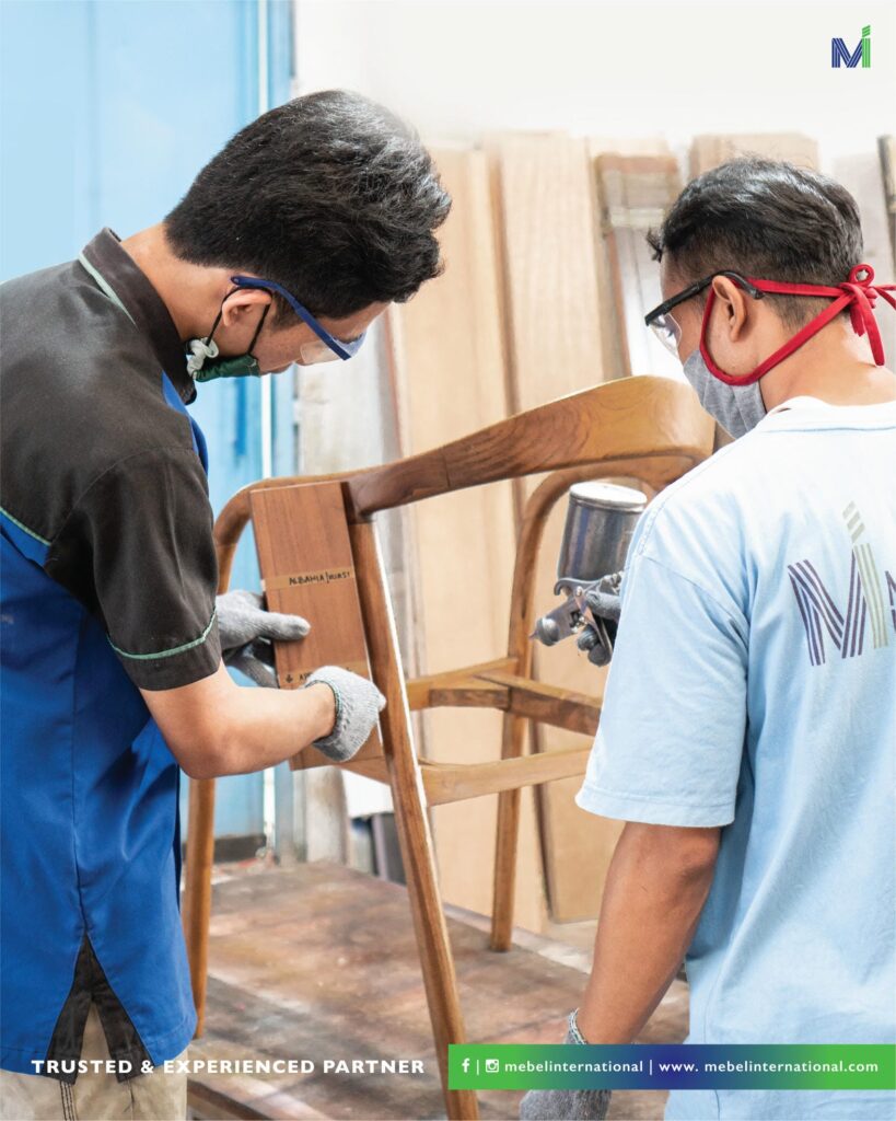 Craftsmen at Mebel International furniture manufacturer inspecting wooden chair frame