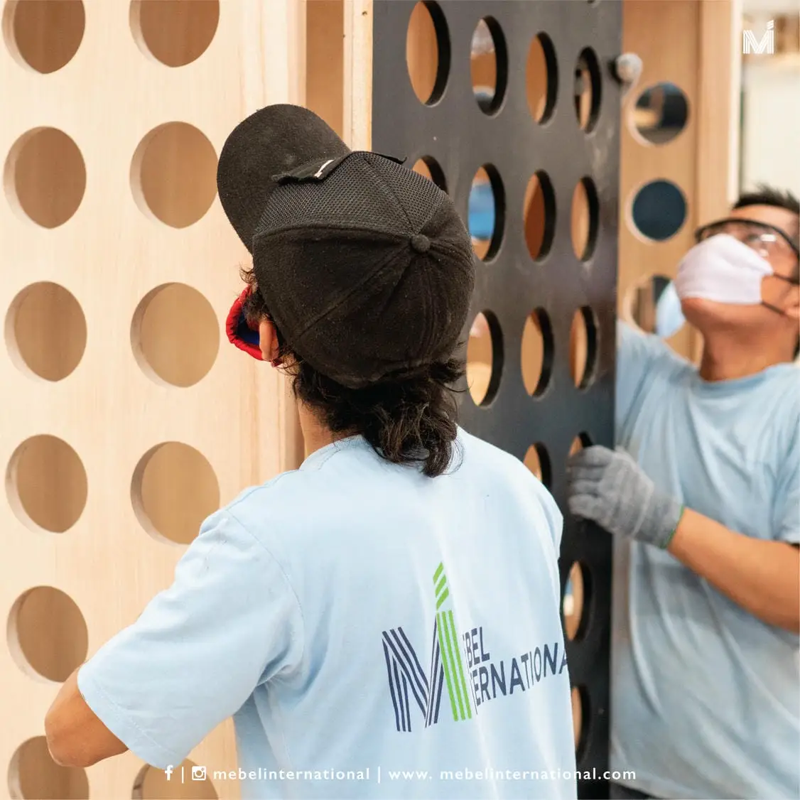 Mebel International furniture manufacturer workers installing perforated wooden panel