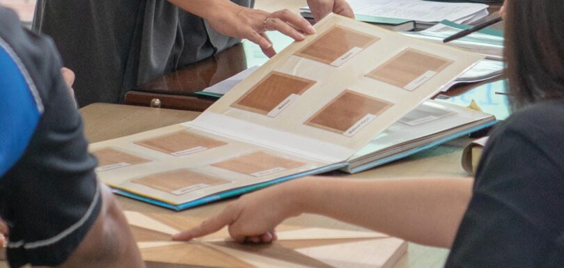 Team at Mebel International furniture manufacturer reviewing wood finish samples