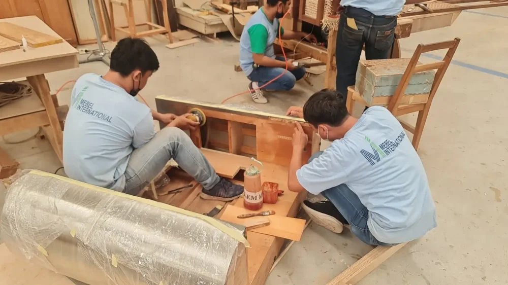 Mebel International furniture manufacturer craftsmen assembling wooden furniture frame in workshop